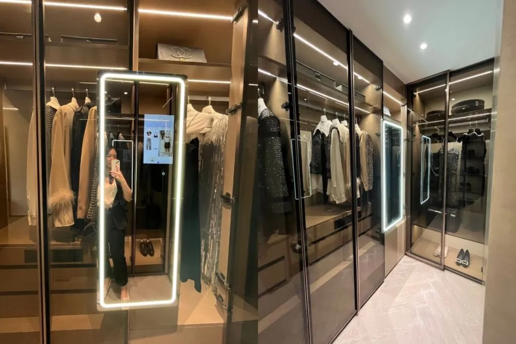 A smart interactive fitting mirror installed in a modern retail dressing room featuring virtual try-on and interactive touchscreen display